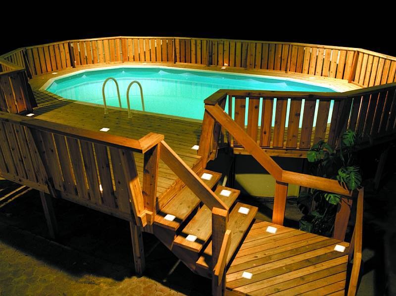 На фото: наземный, круглый бассейн среднего размера на заднем дворе в классическом стиле с настилом с
