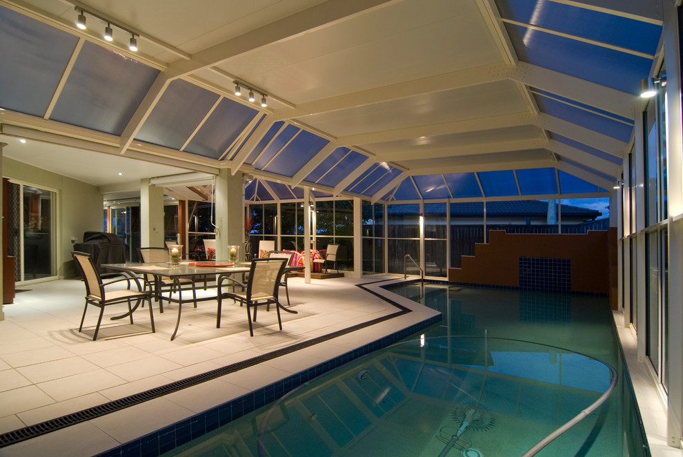 Large indoor custom shaped swimming pool in Brisbane with a pool house and tiled flooring.