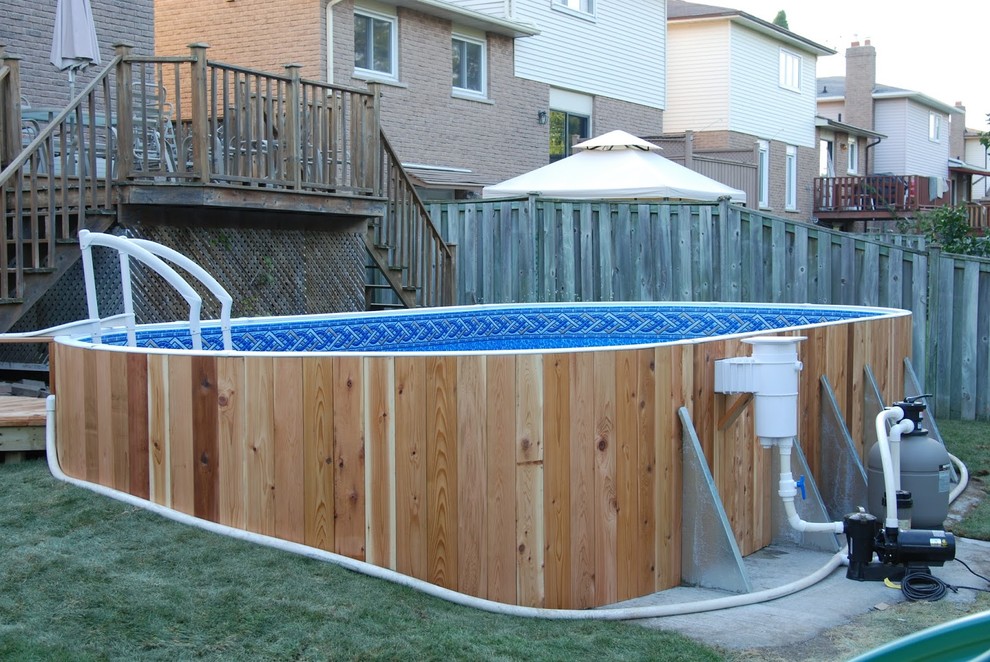 Exemple d'une piscine hors-sol et arrière chic ronde avec une terrasse en bois.