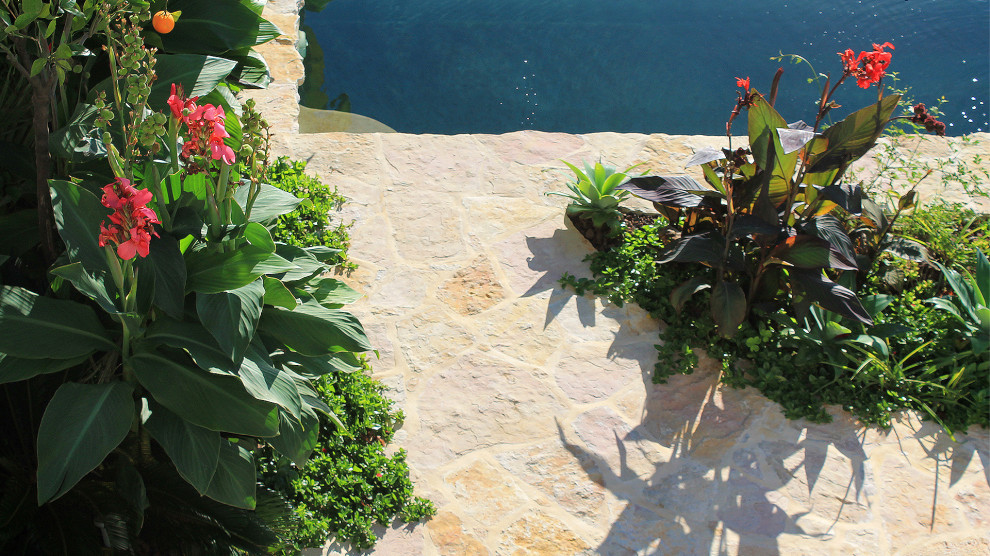 Esempio di una piscina mediterranea con pavimentazioni in pietra naturale e un acquascivolo