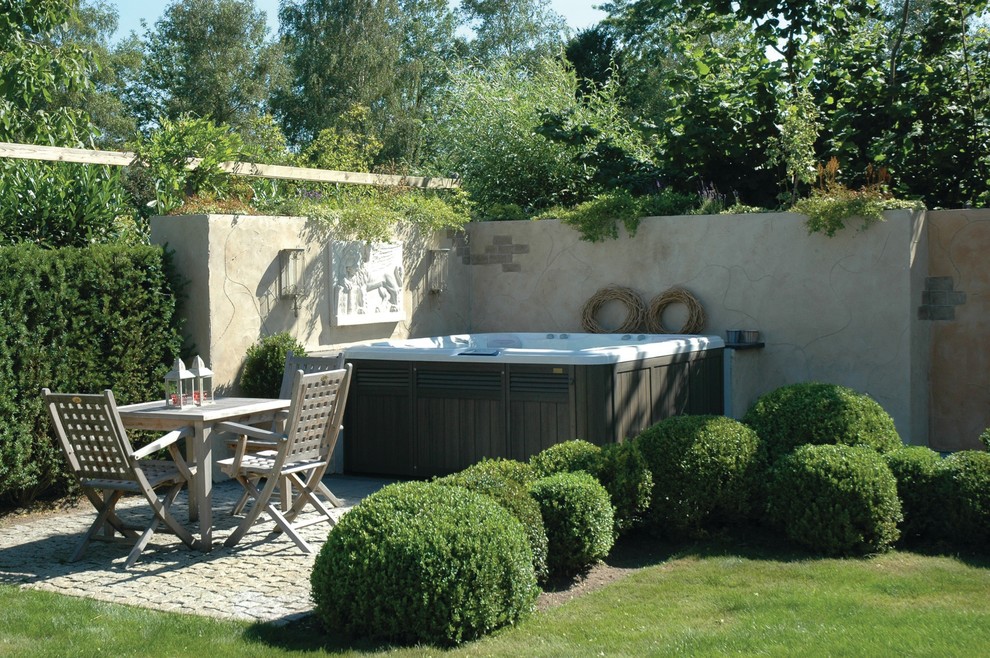 Esempio di una piscina fuori terra classica rettangolare dietro casa con una vasca idromassaggio e cemento stampato
