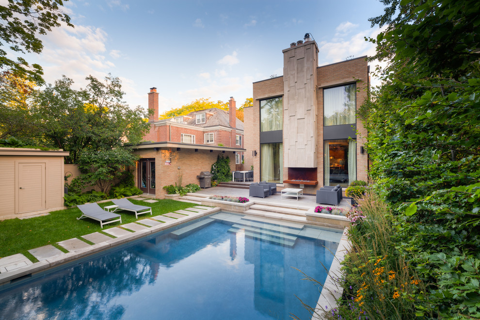 Kleiner Moderner Pool hinter dem Haus in rechteckiger Form mit Wasserspiel und Natursteinplatten in Sonstige