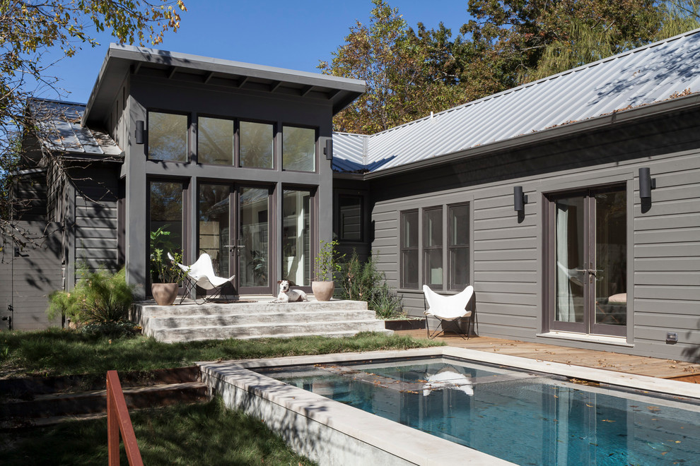 Modelo de piscinas y jacuzzis alargados minimalistas de tamaño medio rectangulares en patio trasero con losas de hormigón