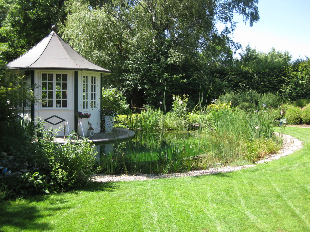 Imagen de piscina natural de estilo de casa de campo pequeña a medida en patio trasero con gravilla
