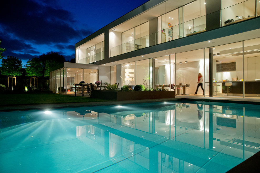 Diseño de piscina alargada actual grande rectangular en patio lateral
