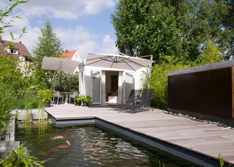 Mittelgroßer Moderner Pool hinter dem Haus in individueller Form mit Dielen in Sonstige