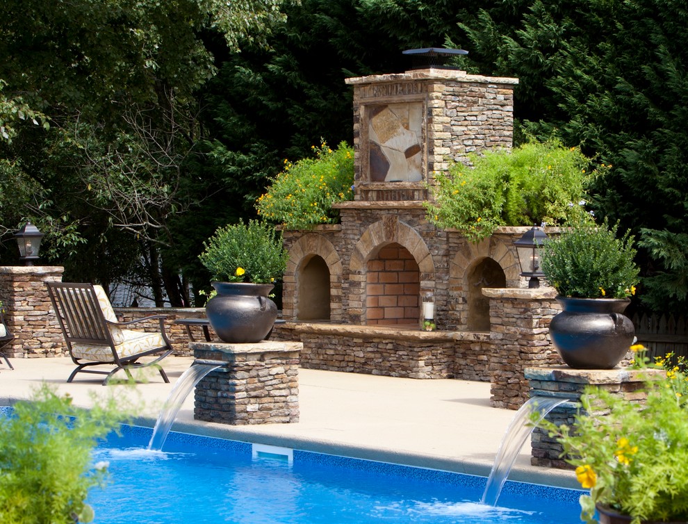 Exempel på en mellanstor klassisk anpassad pool på baksidan av huset, med en fontän och betongplatta