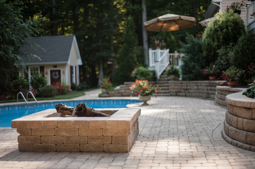 Ispirazione per una grande piscina tradizionale a "C" dietro casa con pavimentazioni in cemento