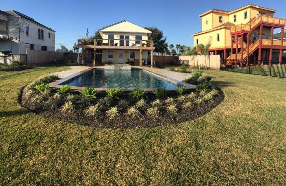 Ejemplo de piscinas y jacuzzis alargados clásicos grandes rectangulares en patio trasero con losas de hormigón