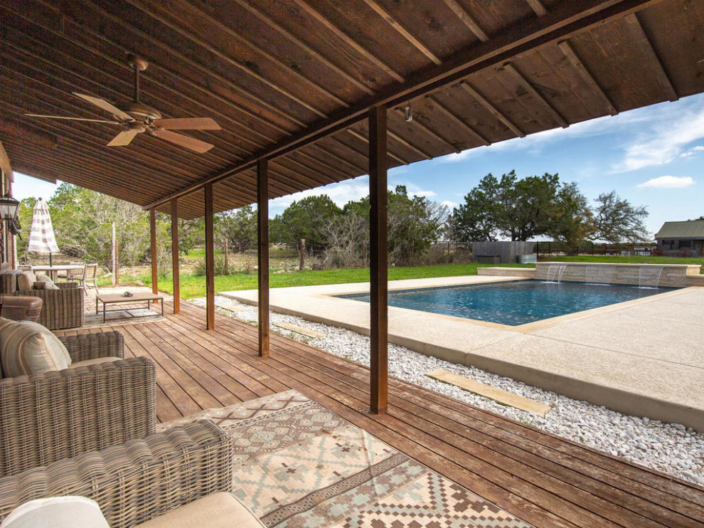 Ejemplo de piscina de estilo de casa de campo de tamaño medio rectangular en patio lateral con suelo de hormigón estampado