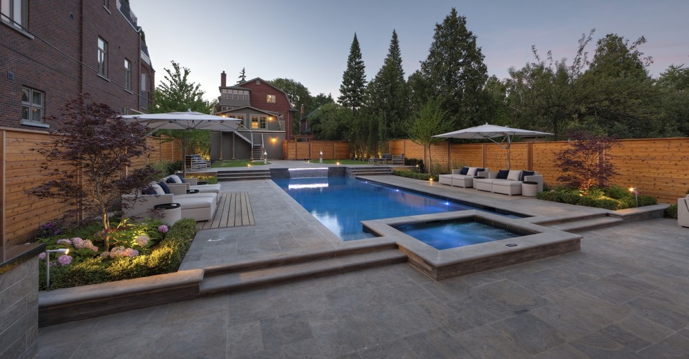 Пример оригинального дизайна: большой спортивный, прямоугольный бассейн на заднем дворе в современном стиле с джакузи и покрытием из каменной брусчатки