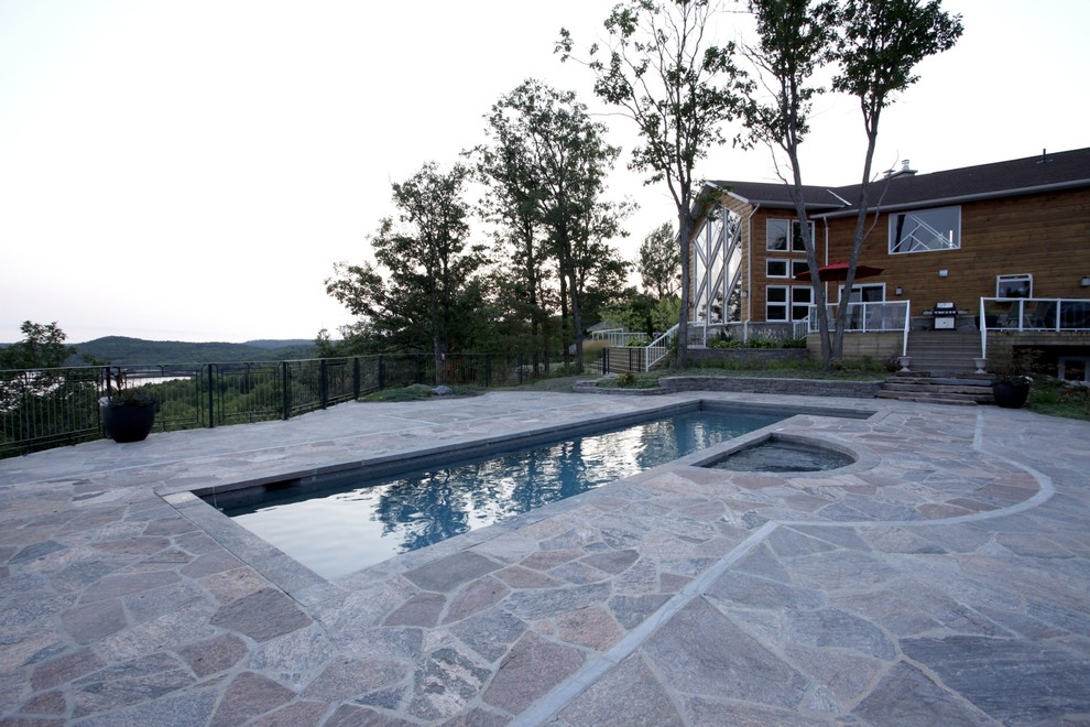 Пример оригинального дизайна: большой спортивный, прямоугольный бассейн на боковом дворе в современном стиле с джакузи и покрытием из каменной брусчатки