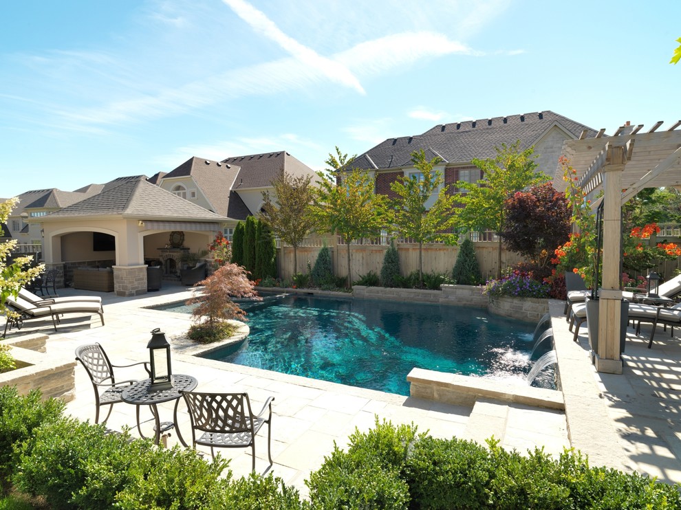 Ejemplo de casa de la piscina y piscina alargada contemporánea de tamaño medio a medida en patio trasero con adoquines de piedra natural