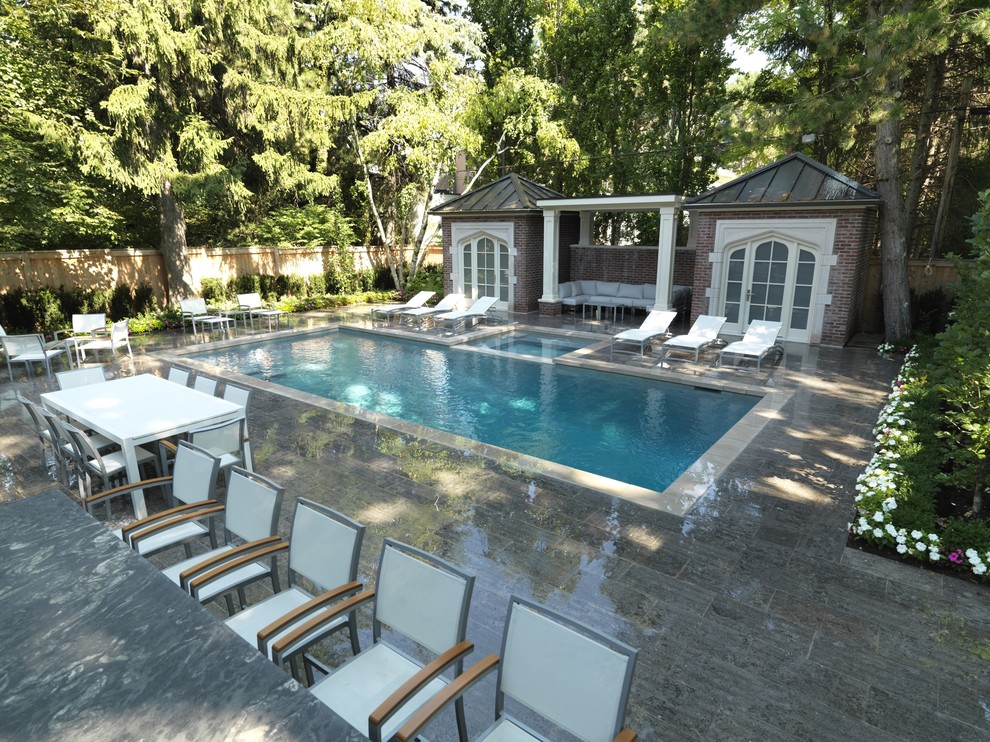На фото: спортивный, прямоугольный бассейн среднего размера на заднем дворе в современном стиле с домиком у бассейна и покрытием из каменной брусчатки