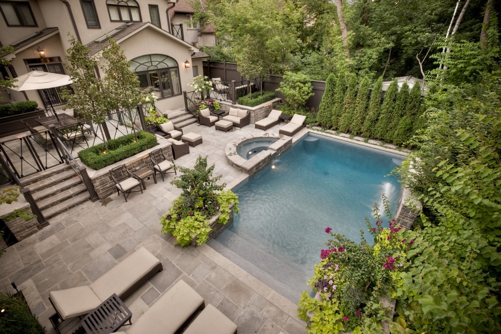 Esempio di una piscina minimal rettangolare di medie dimensioni e dietro casa con una vasca idromassaggio e pavimentazioni in pietra naturale