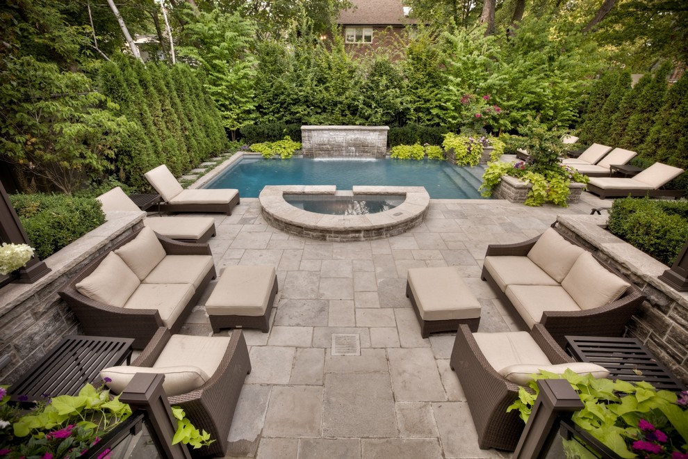 Photo of a medium sized contemporary back rectangular hot tub in Toronto with natural stone paving.