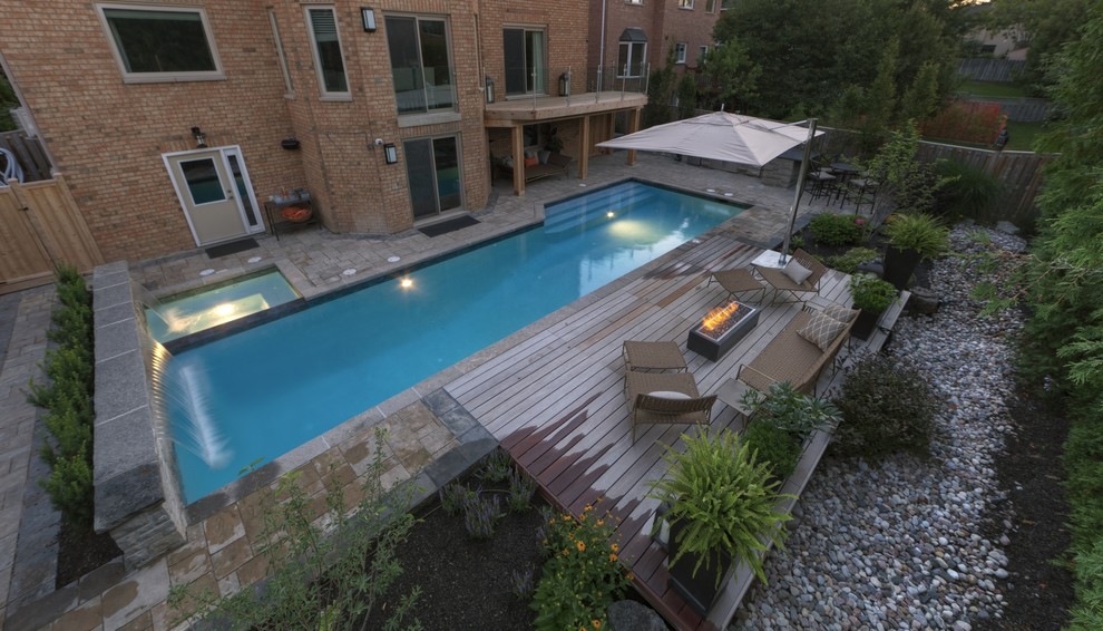 Large trendy backyard stone and rectangular lap hot tub photo in Toronto