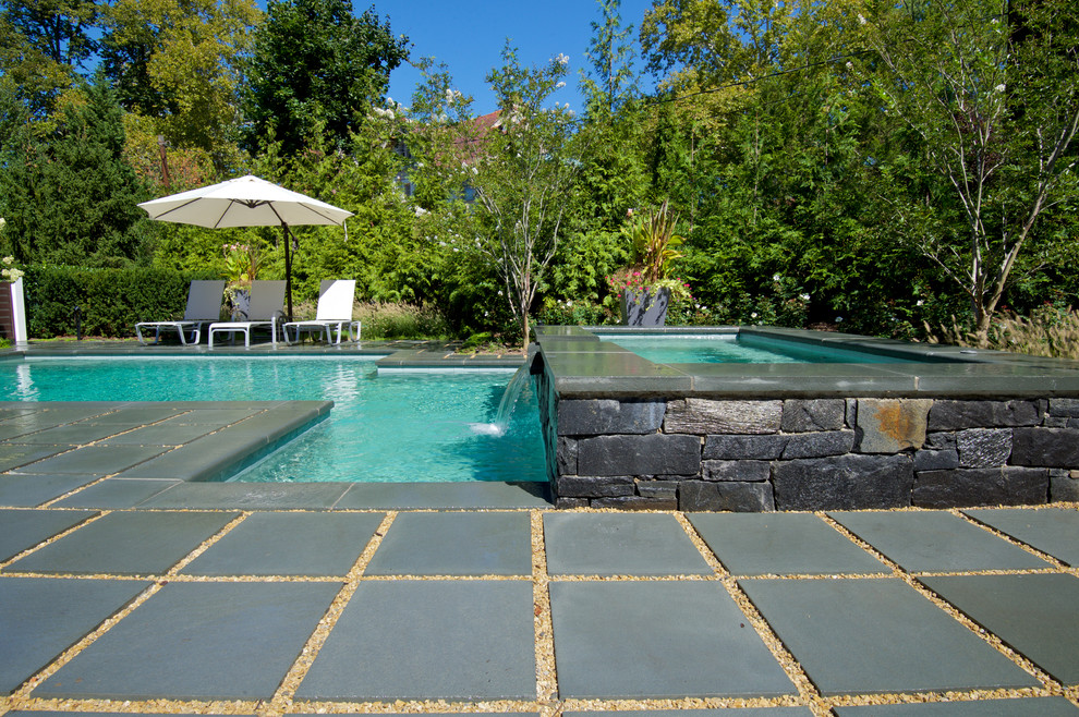 Ejemplo de piscinas y jacuzzis actuales pequeños a medida en patio trasero con adoquines de piedra natural