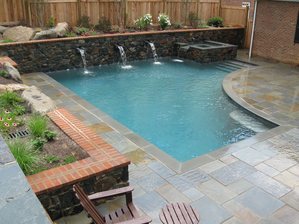Imagen de piscina con fuente actual pequeña a medida en patio trasero con adoquines de piedra natural