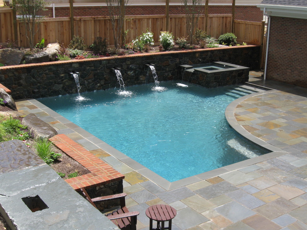 Modelo de piscina con fuente actual pequeña a medida en patio trasero con adoquines de piedra natural