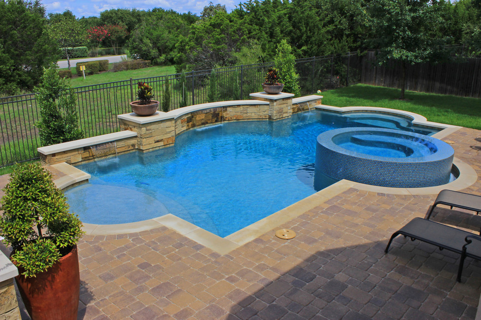 Idee per una grande piscina naturale chic personalizzata dietro casa con una vasca idromassaggio e pavimentazioni in mattoni
