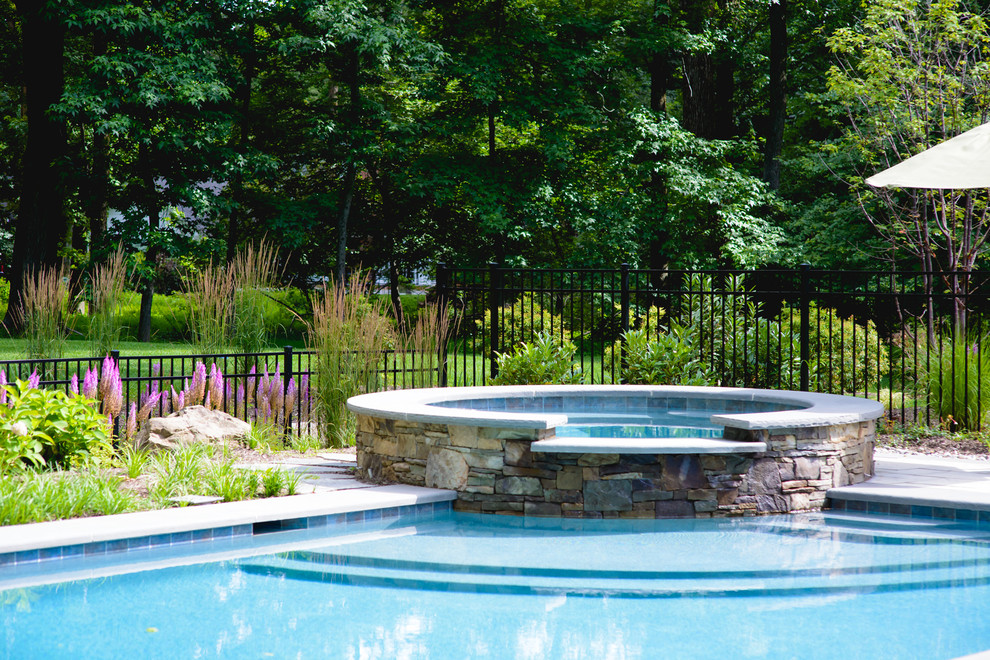 Foto de piscina natural contemporánea grande rectangular en patio trasero con adoquines de hormigón