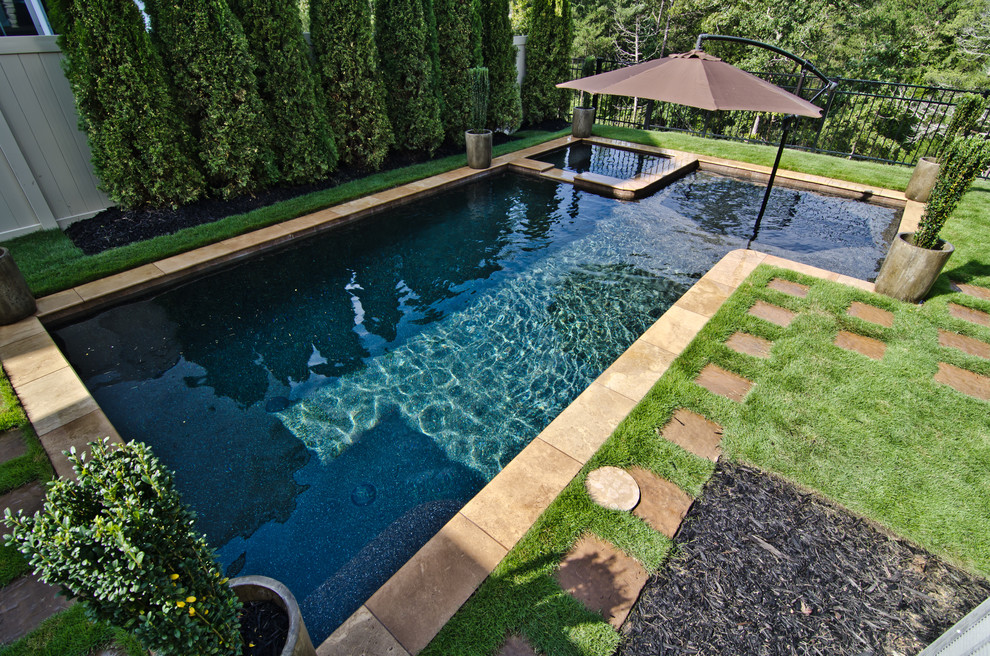 Imagen de piscinas y jacuzzis actuales de tamaño medio rectangulares en patio trasero