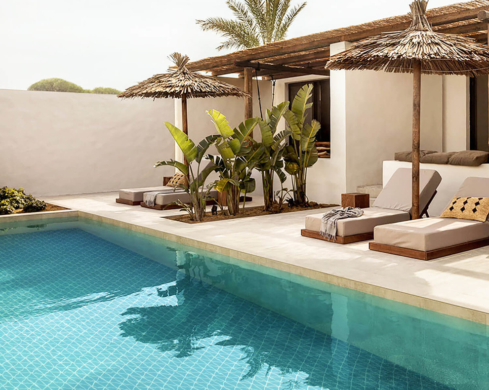 На фото: наземный, угловой бассейн на внутреннем дворе в средиземноморском стиле с домиком у бассейна и покрытием из плитки