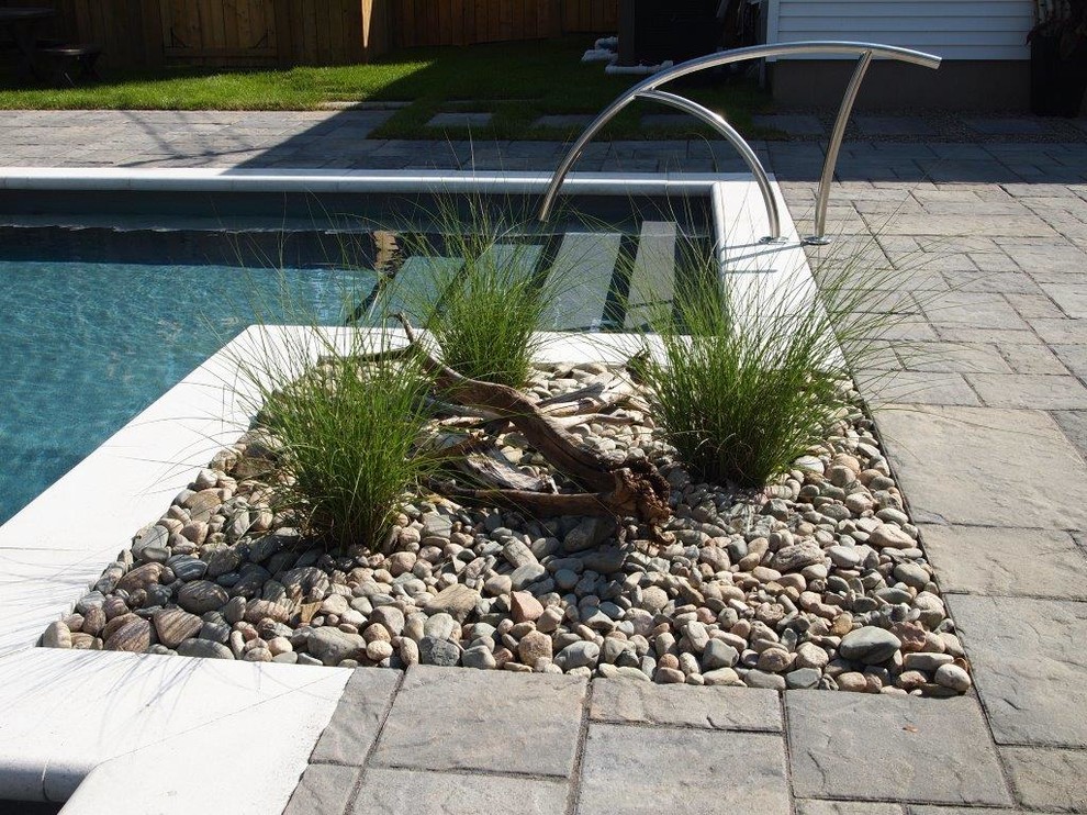 Exemple d'une piscine arrière tendance de taille moyenne et sur mesure avec des pavés en béton.