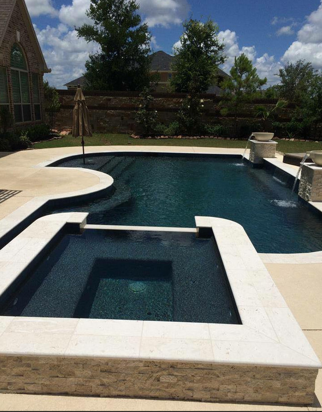 Inspiration for a large contemporary backyard stone and custom-shaped natural pool fountain remodel in Houston