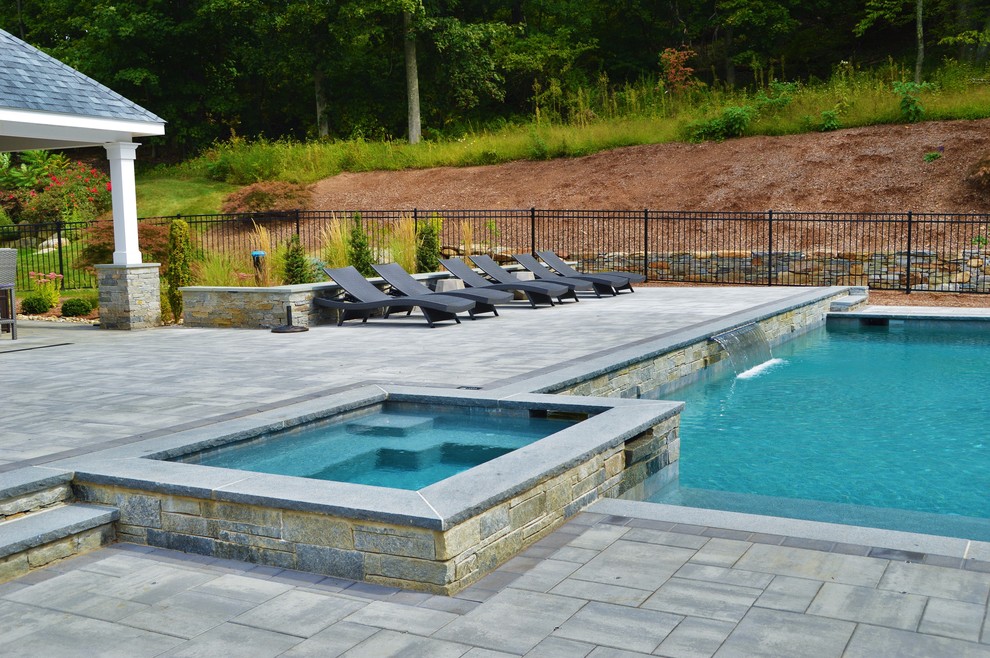 Hot tub - large traditional backyard concrete paver and custom-shaped natural hot tub idea in Bridgeport