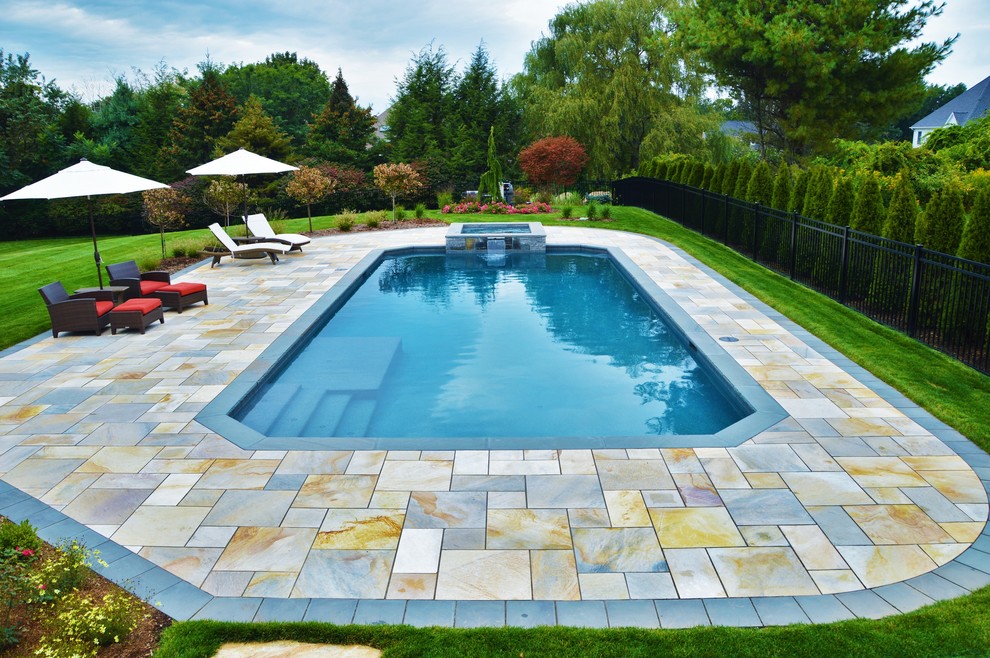 Inspiration pour une grande piscine naturelle et arrière traditionnelle rectangle avec un bain bouillonnant et des pavés en béton.