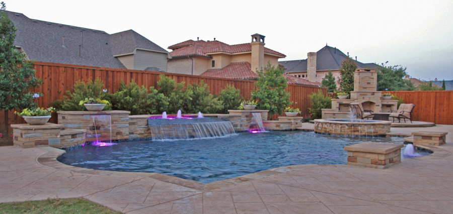 Design ideas for a large modern back custom shaped lengths swimming pool in Dallas with a water feature and natural stone paving.