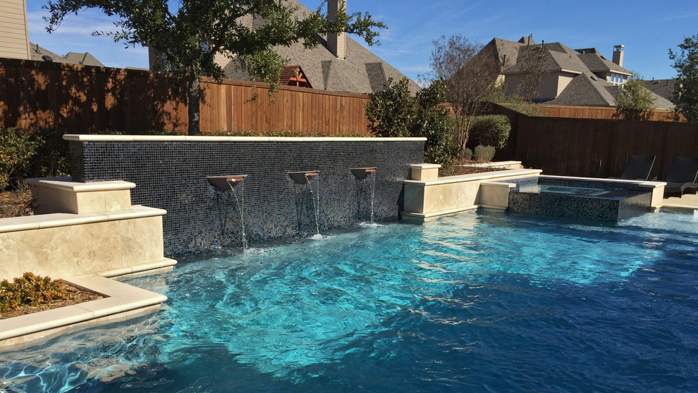 Modelo de piscina con fuente alargada moderna de tamaño medio a medida en patio trasero con adoquines de piedra natural