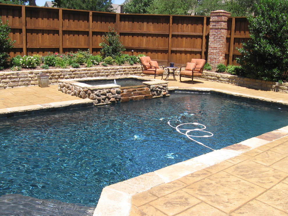 Ejemplo de piscinas y jacuzzis naturales tropicales de tamaño medio rectangulares en patio trasero con adoquines de piedra natural