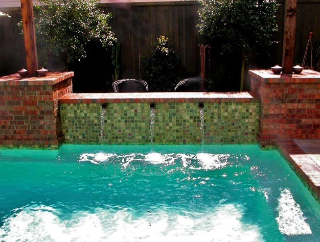 Ispirazione per una grande piscina moderna rettangolare dietro casa con fontane e cemento stampato