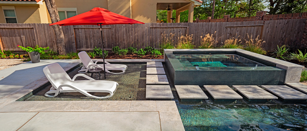 Exemple d'une piscine arrière tendance de taille moyenne et rectangle avec un point d'eau et une dalle de béton.
