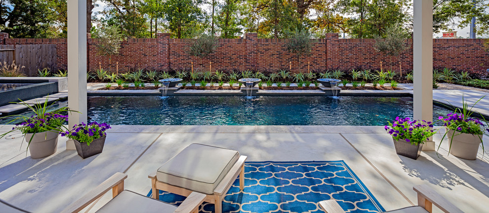 Inspiration for a mid-sized contemporary backyard concrete and rectangular pool fountain remodel in Houston