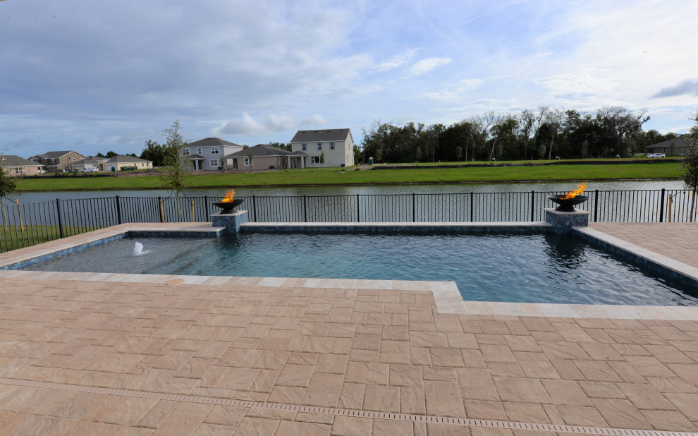 Cette photo montre une piscine arrière moderne de taille moyenne et rectangle avec des pavés en brique.