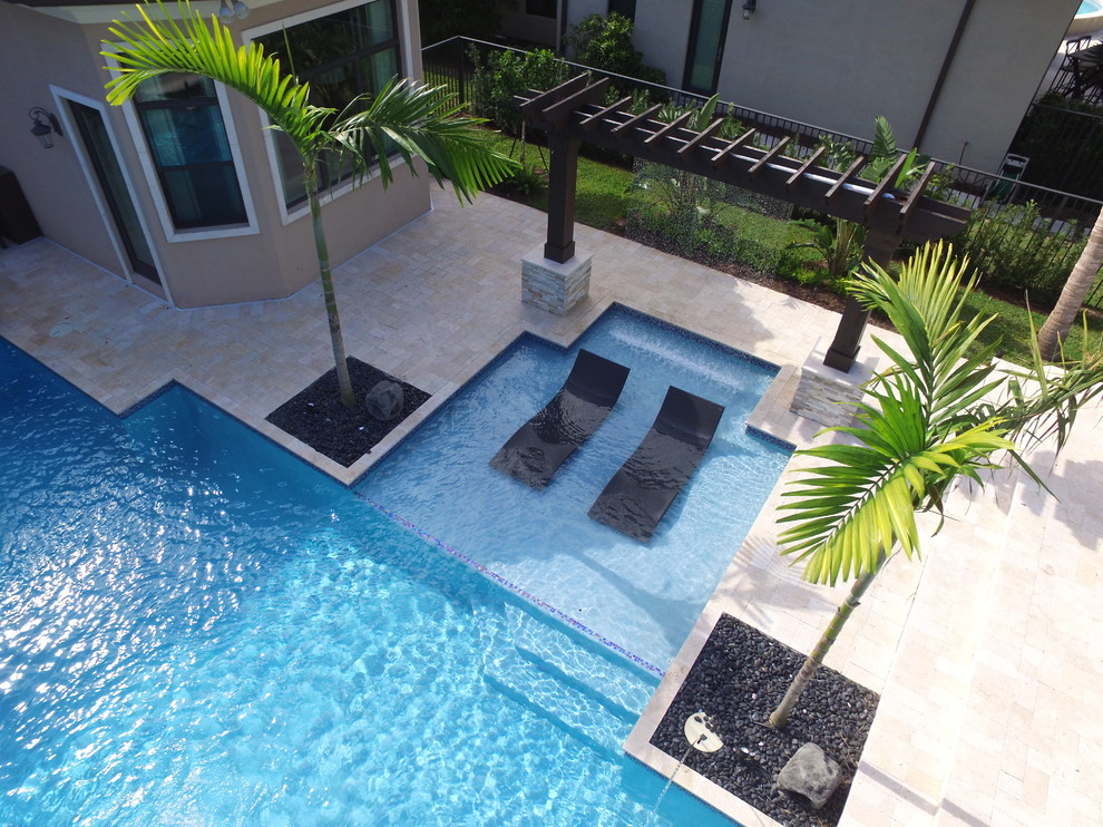 Foto de piscina con fuente actual grande a medida en patio trasero con entablado