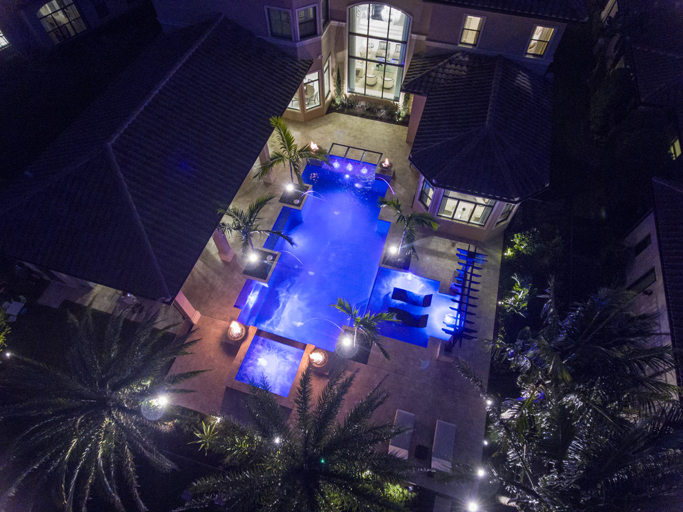 На фото: большой бассейн произвольной формы на заднем дворе в современном стиле с джакузи и настилом