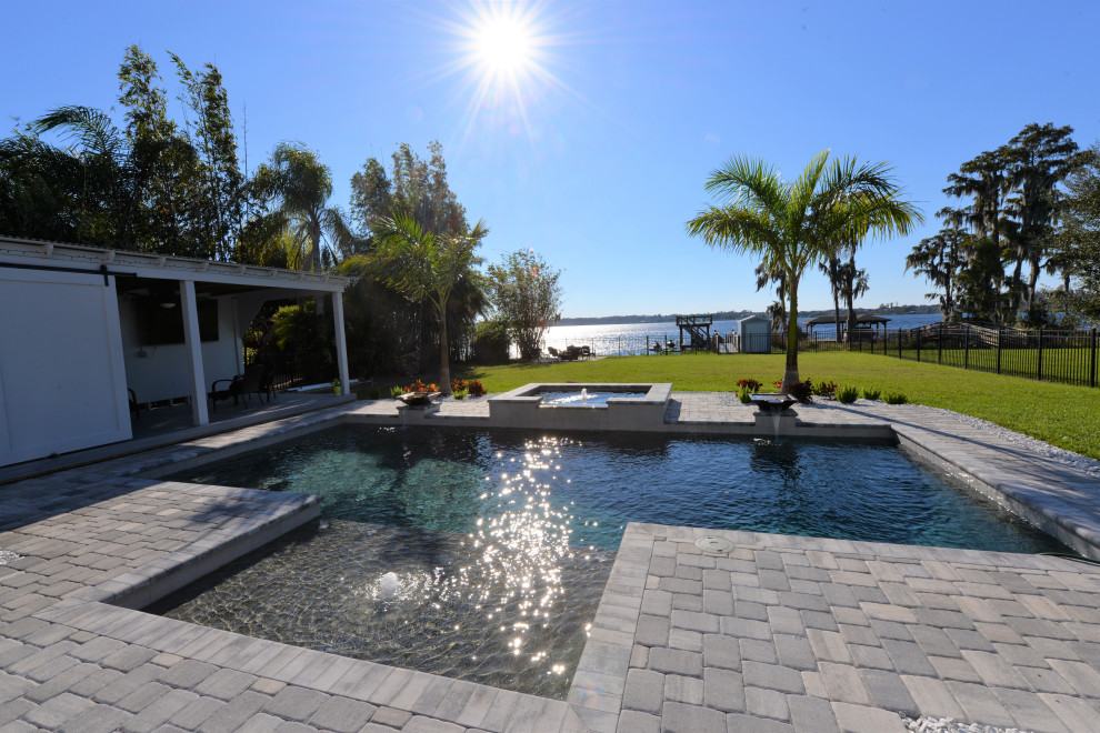 This is an example of a large traditional back rectangular swimming pool in Orlando with brick paving.