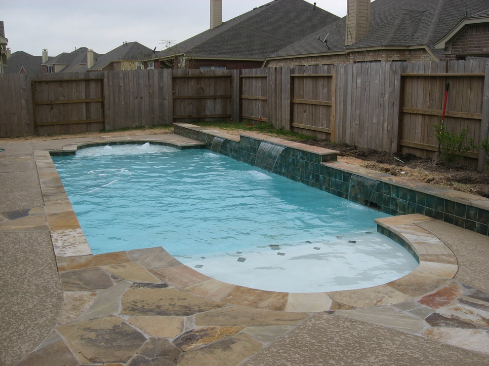 Imagen de piscina con fuente natural clásica de tamaño medio rectangular en patio trasero con entablado