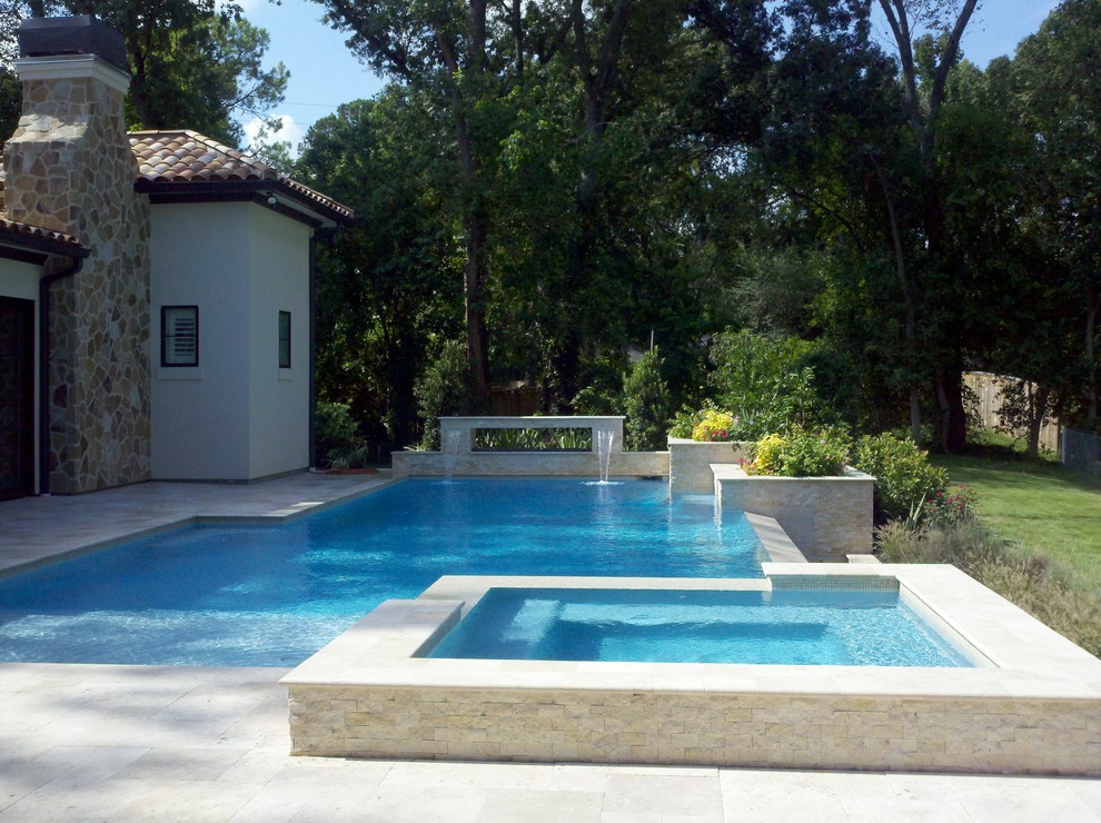 Immagine di una piscina a sfioro infinito design personalizzata di medie dimensioni e dietro casa con pavimentazioni in pietra naturale e una vasca idromassaggio