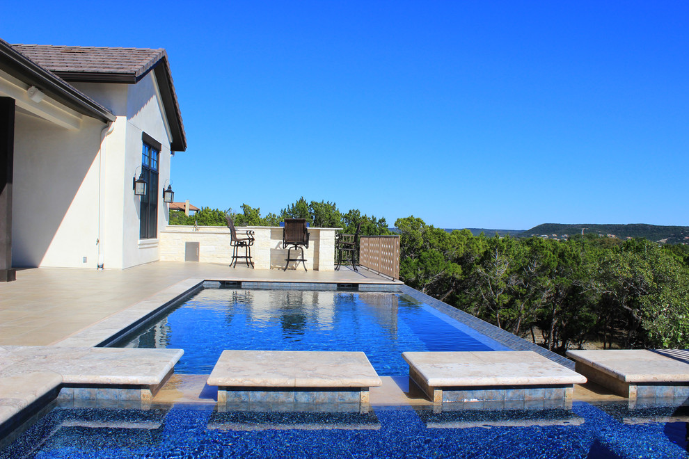 Diseño de piscinas y jacuzzis infinitos contemporáneos de tamaño medio a medida en patio trasero con suelo de baldosas