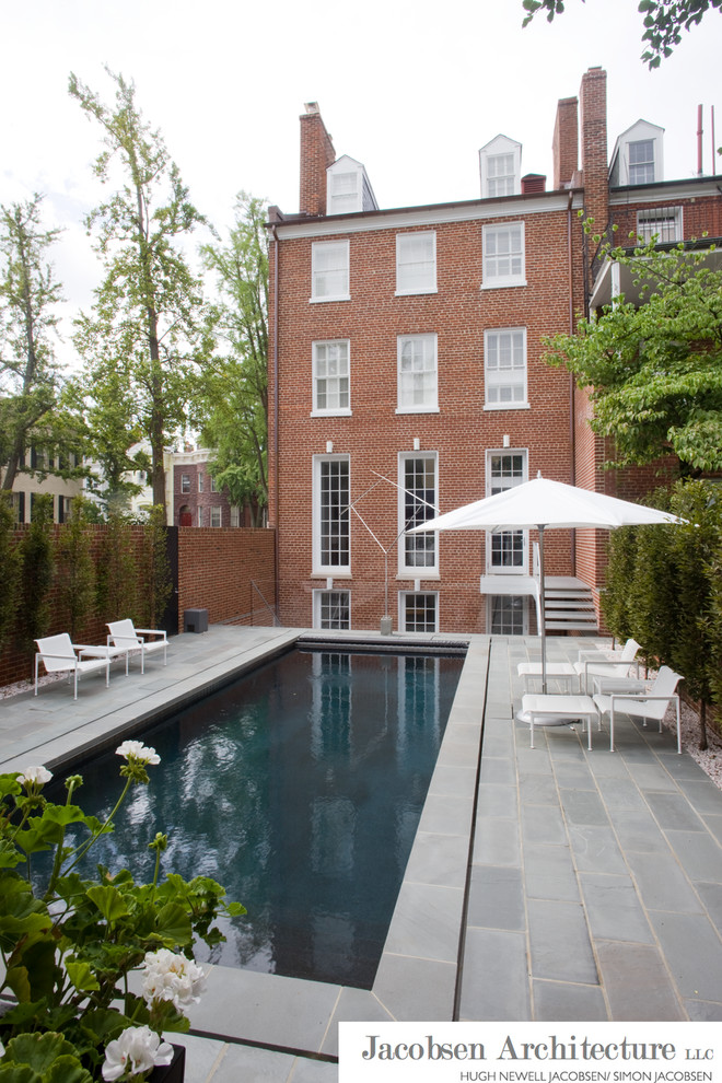 Esempio di una piscina monocorsia minimal rettangolare dietro casa con pavimentazioni in pietra naturale e una vasca idromassaggio