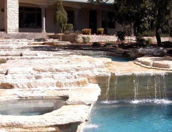Idee per una grande piscina monocorsia mediterranea rotonda dietro casa con fontane e pavimentazioni in pietra naturale