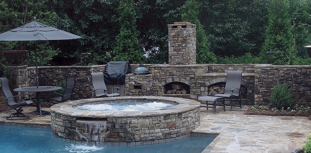 Foto de piscina alargada tradicional de tamaño medio rectangular en patio trasero con adoquines de piedra natural