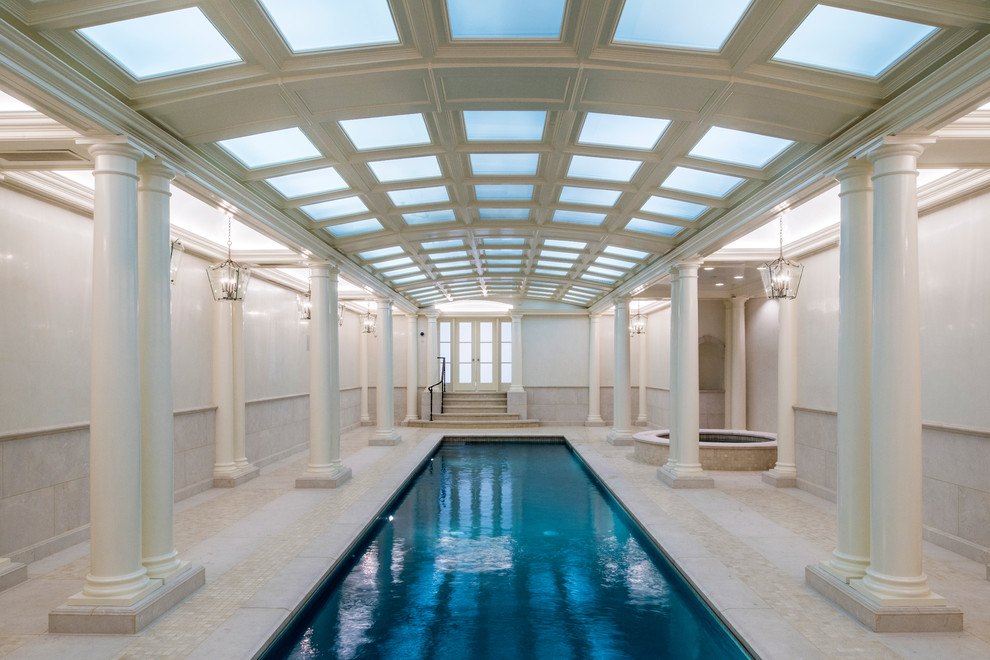 Cette image montre une grande piscine intérieure traditionnelle rectangle avec un bain bouillonnant et du carrelage.