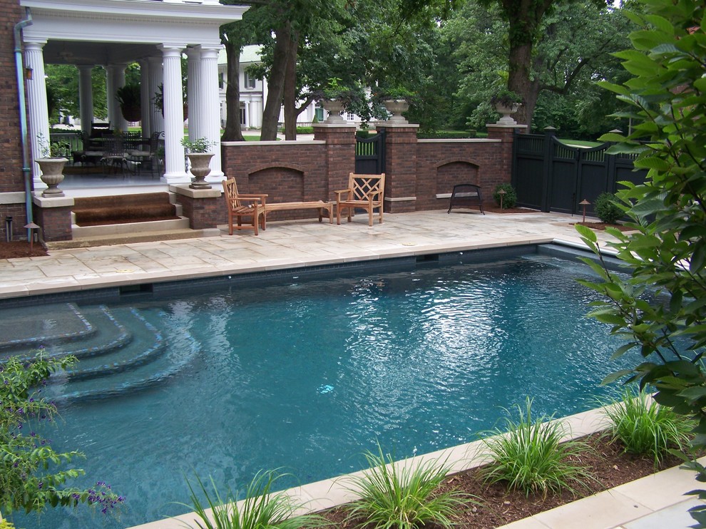 Réalisation d'une piscine naturelle et latérale tradition rectangle et de taille moyenne avec du béton estampé.